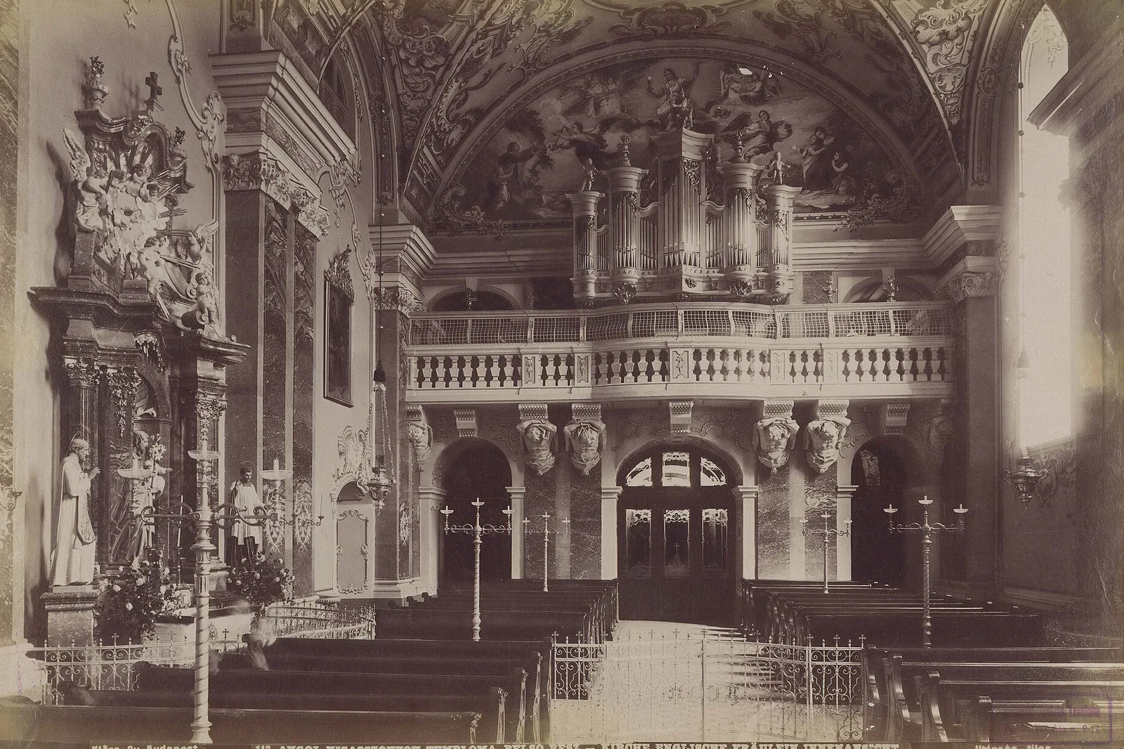 Et sepiafotografi af kirkens interiør fra omkring 1892, der viser orgelgalleriet over en balustrade, marmorpilastre, et alter til venstre og rækker af kirkebænke foran