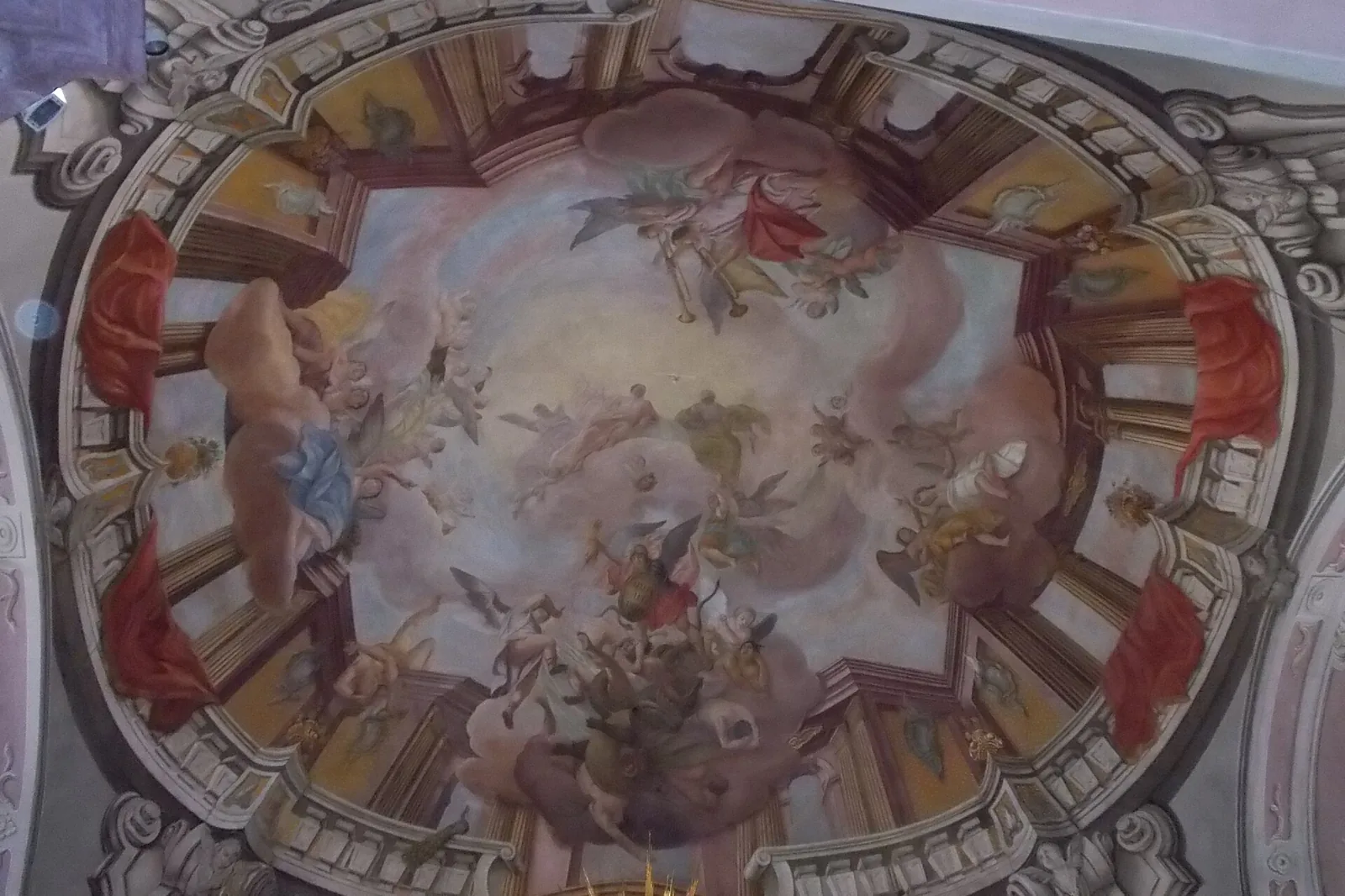 Et loftsfresko i kirken, en oval scene med figurer blandt skyer, indrammet af malet arkitektur og stuk